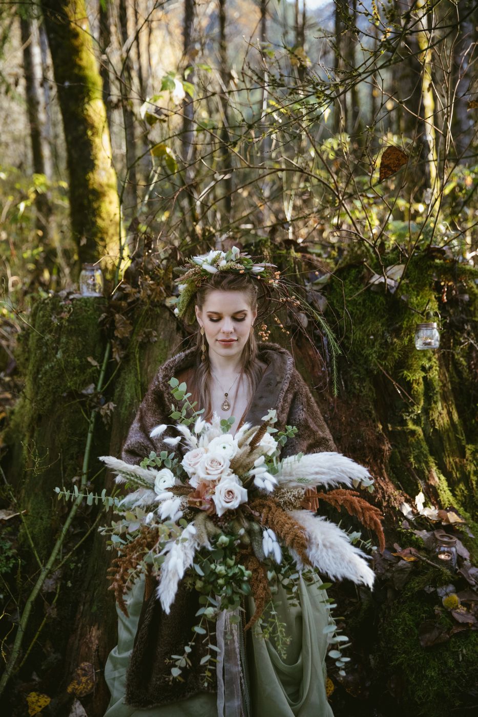 Bride in forest with fall bouquet of ferns and white flowers