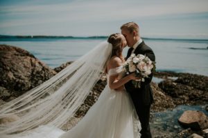 Romantic first look couple on the Vancouver Island ocean with bride in cathedral veil