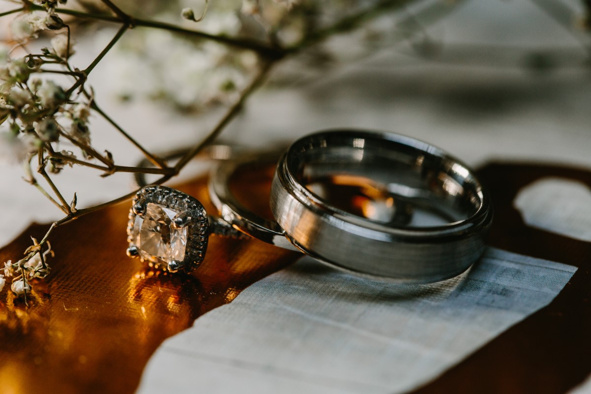Silver wedding ring on orange linen by Jon Mark Photo
