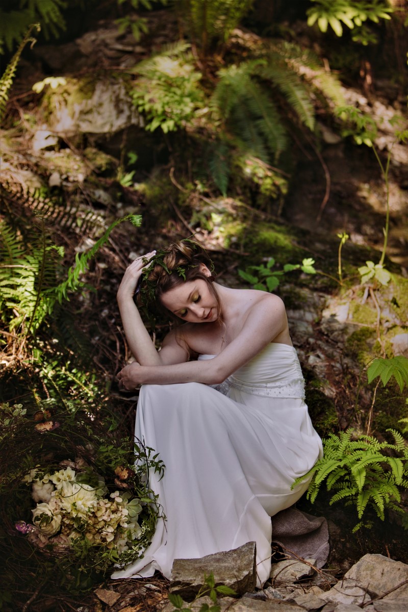 Bride among ferns in forest by Deborah Lee Designs