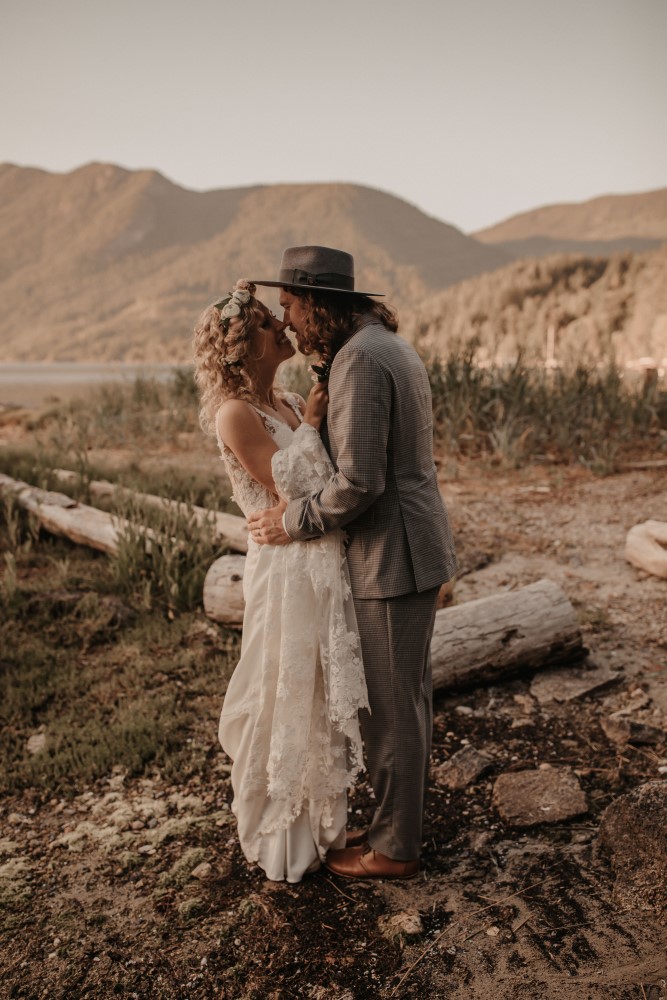 Golden hour Bride and groom touching noses holding each other mountains and sand