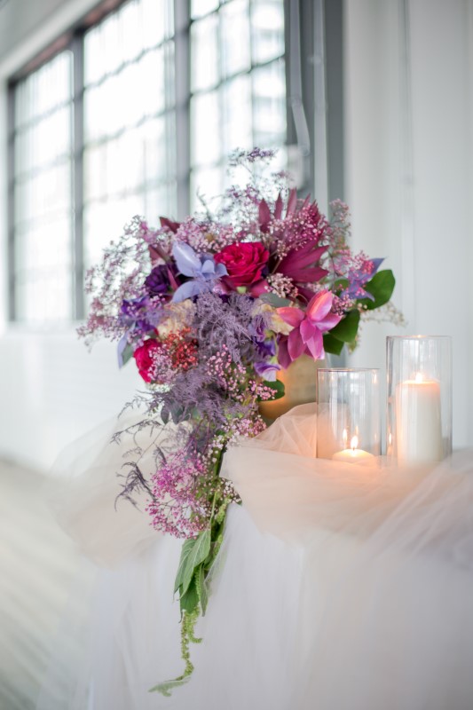 Purple and pink floral arrangement on wedding head table by Karen Wazny in Vancouver