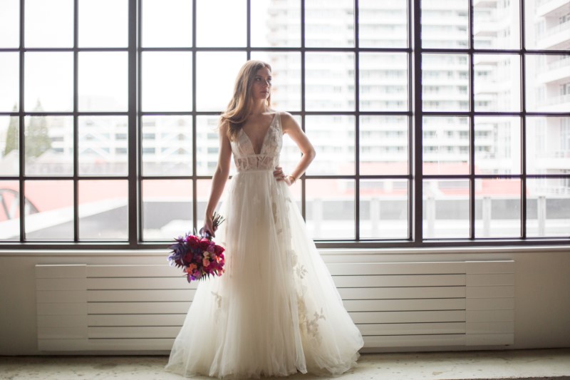Bride in front of window in Willowby by Watters gown