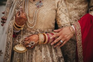 Luxury Indian Wedding Newlyweds hands with rings and henna by Pristine Allure Studio