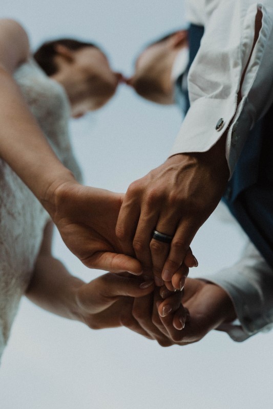 Bride and groom's hold hands by Kacie McColm