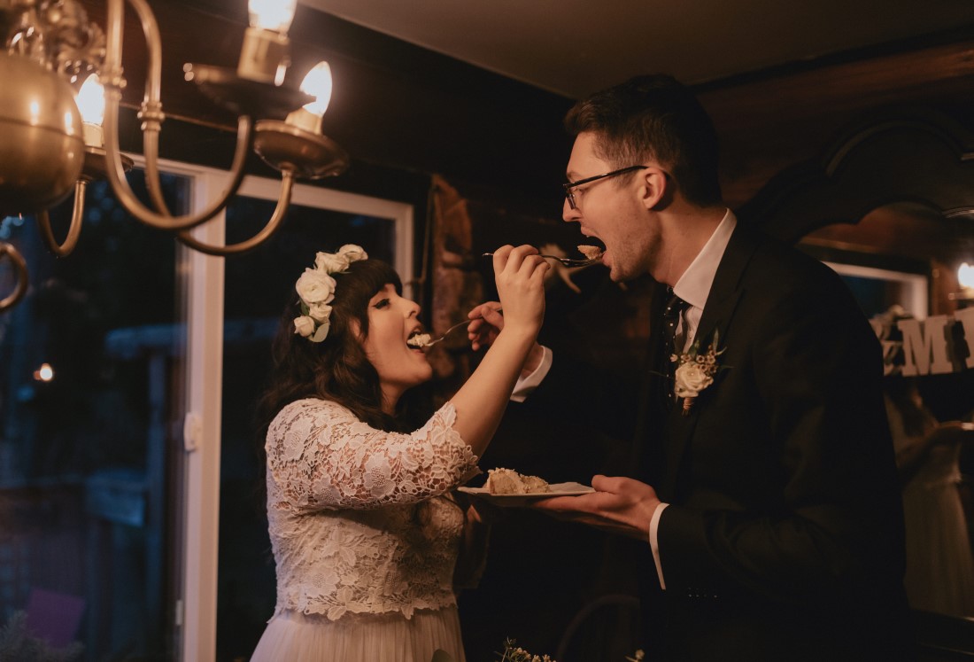 Bride and groom feed each other Sweet Athena cake 
