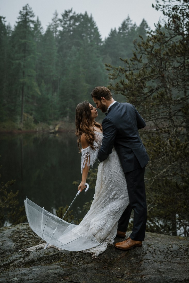 Bride with battenburg lace parasol kisses groom 