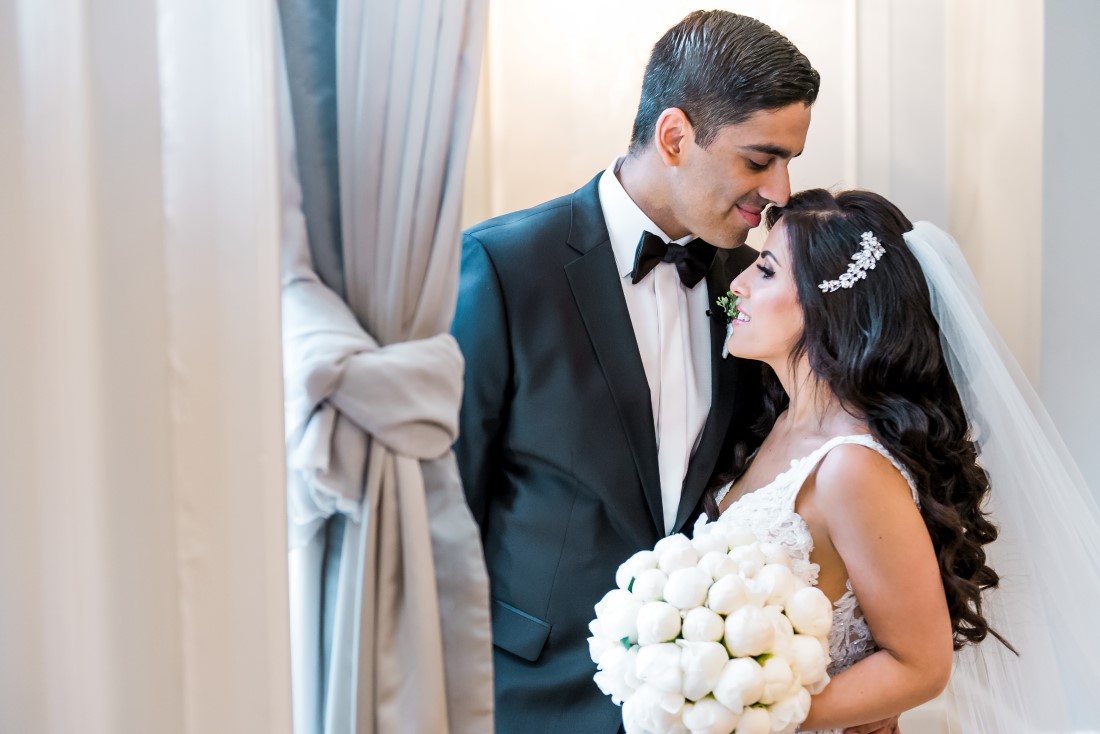 Newlyweds portrait at Vancouver Club with bridal bouquet of white peonies by Tala Florist
