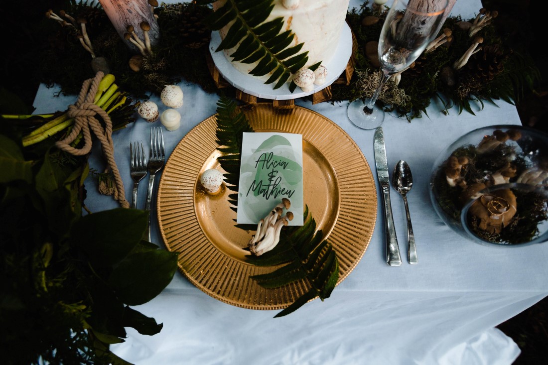 Gold plate and ferns on reception table with paper name card