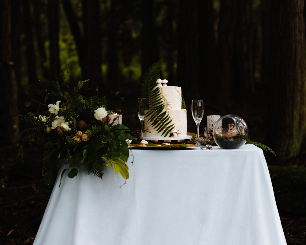 Enchanted Storybook Wedding Table in the forest with cake and flowers