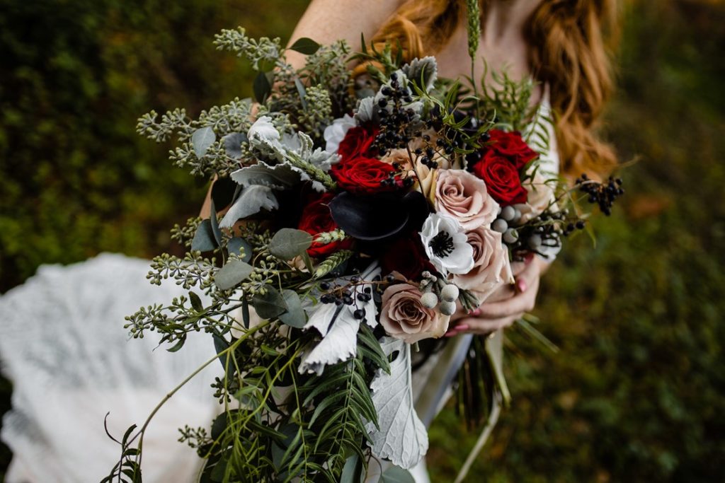 Bridal bouquet with white anemone, red roses, white roses, dusty miller and blue thistle by Edelweiss Floral Vancouver