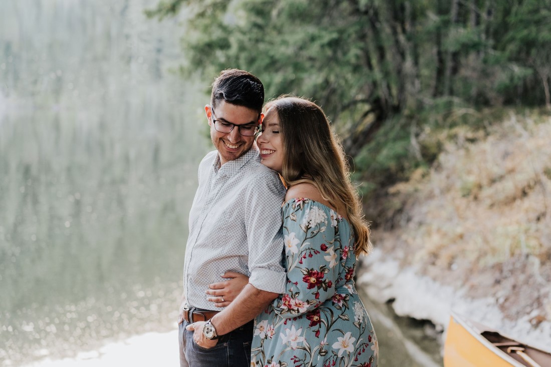 Engaged couple embraces by lake on Vancouver Island