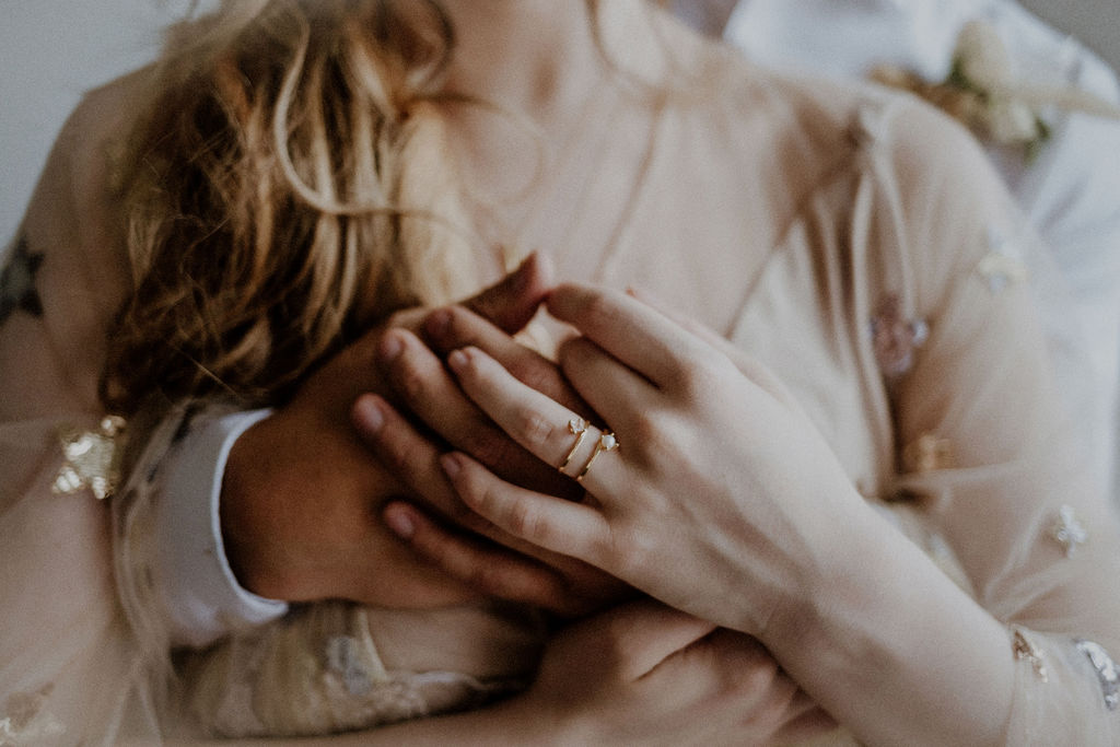 Bride and Groom's hands entwined around ring by Sarah England Photography