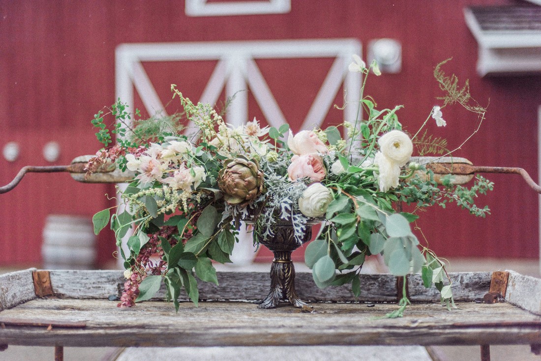Bridal bouquets sit in front of red wood barn in Vancouver