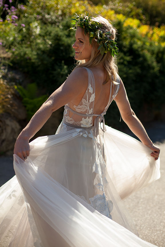 Bride wearing floral wreath twirls her wedding gown skirt