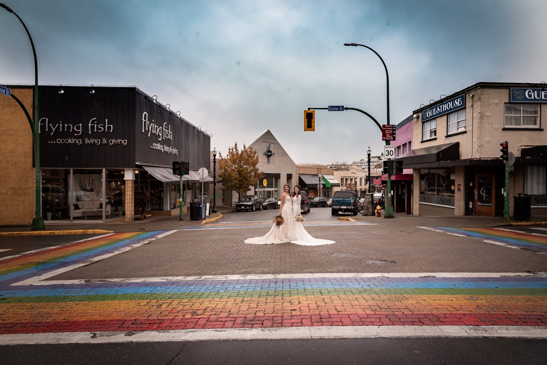 LGBTQ friendly brides stand iamong rainbow colours on the street in Nanaimo 