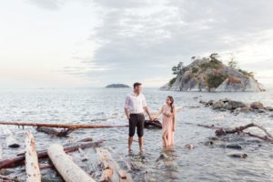 Whytecliff Park Engagement couple walk through the waves along Vancouver beach
