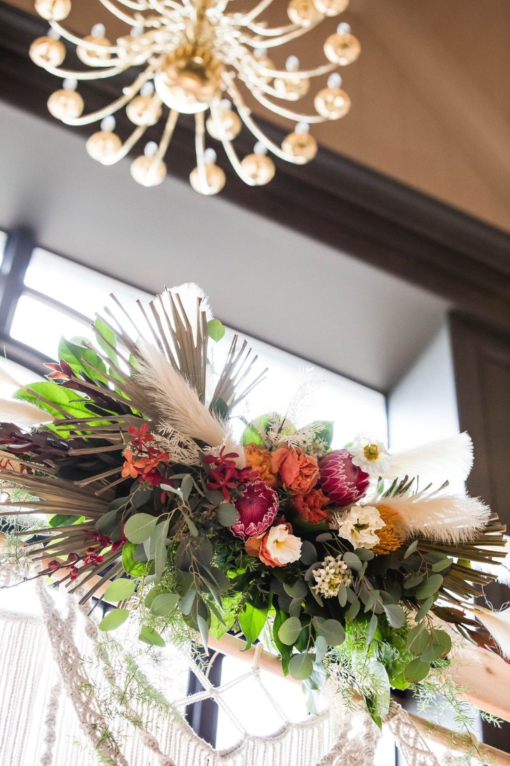 Flowers on wood ceremony arch feature pampas grass, eucalyptus and peach, pink and white roses by Maple Ridge Floral Ltd Vancouver