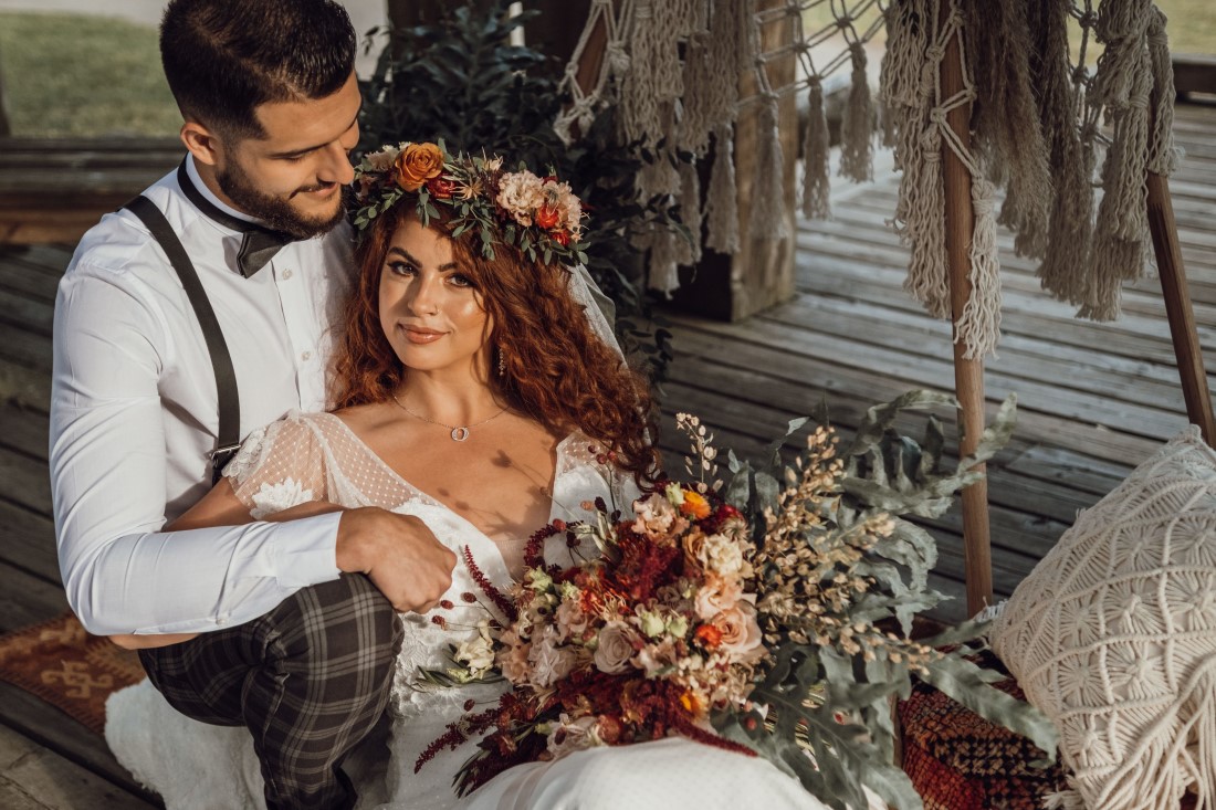 Bride wearing floral crown leans on groom