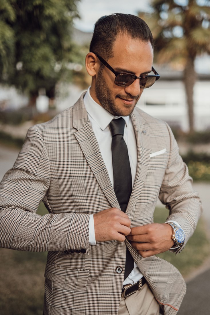 Groom in sunglasses buttons suit