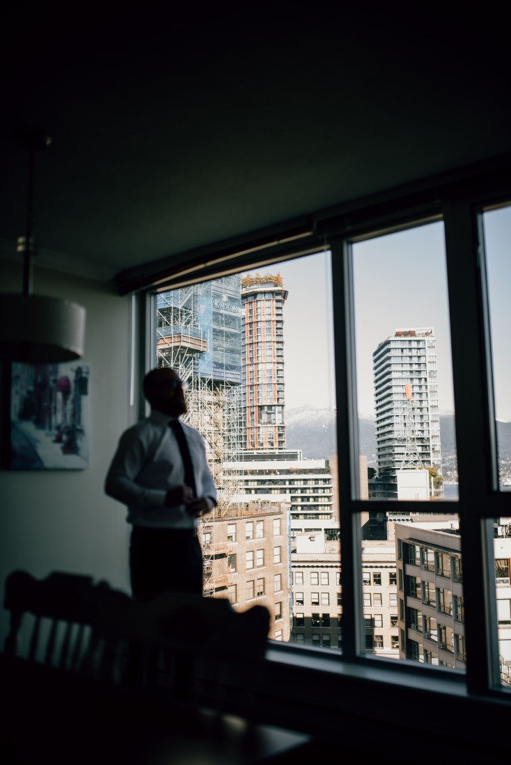 Vancouver groom looks out window at city 