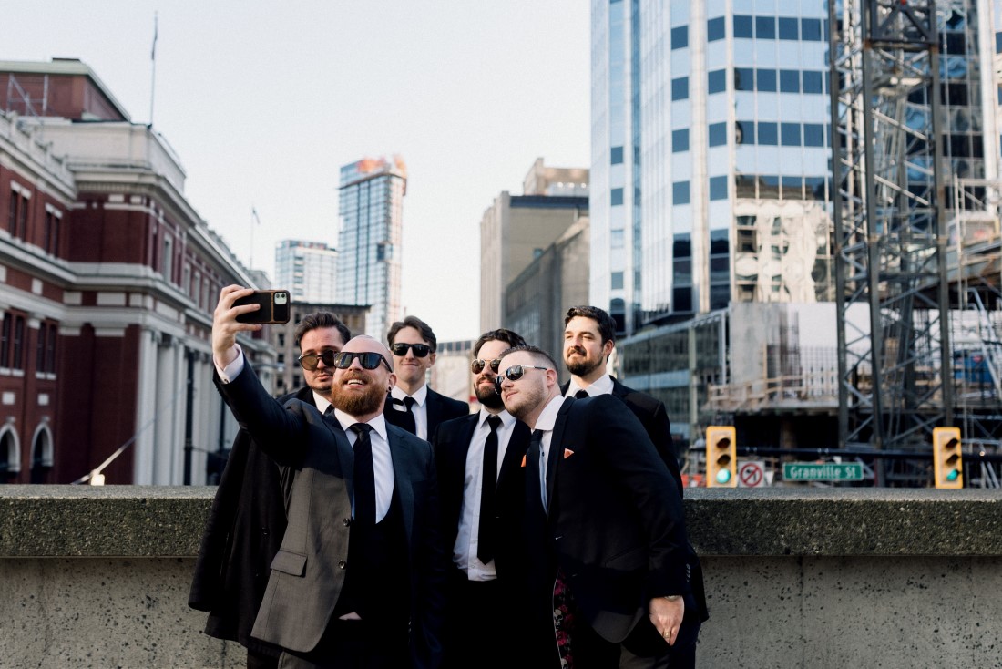 Downtown Devotion groomsman take selfie group shot of Vancouver skyline