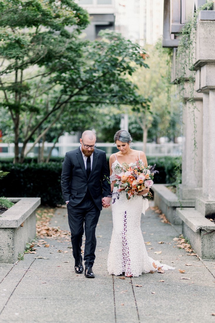 Newlyweds walk hand in hand through downtown Vancouver