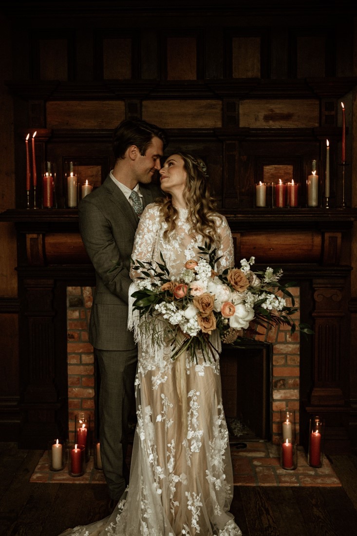 Rustic Romance Newlyweds kiss in front of the fireplace at Keating Farm Vancouver Island