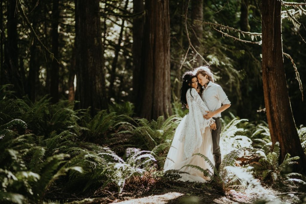 Whimsical & Woodsy newlyweds kiss under the sun dappled forest