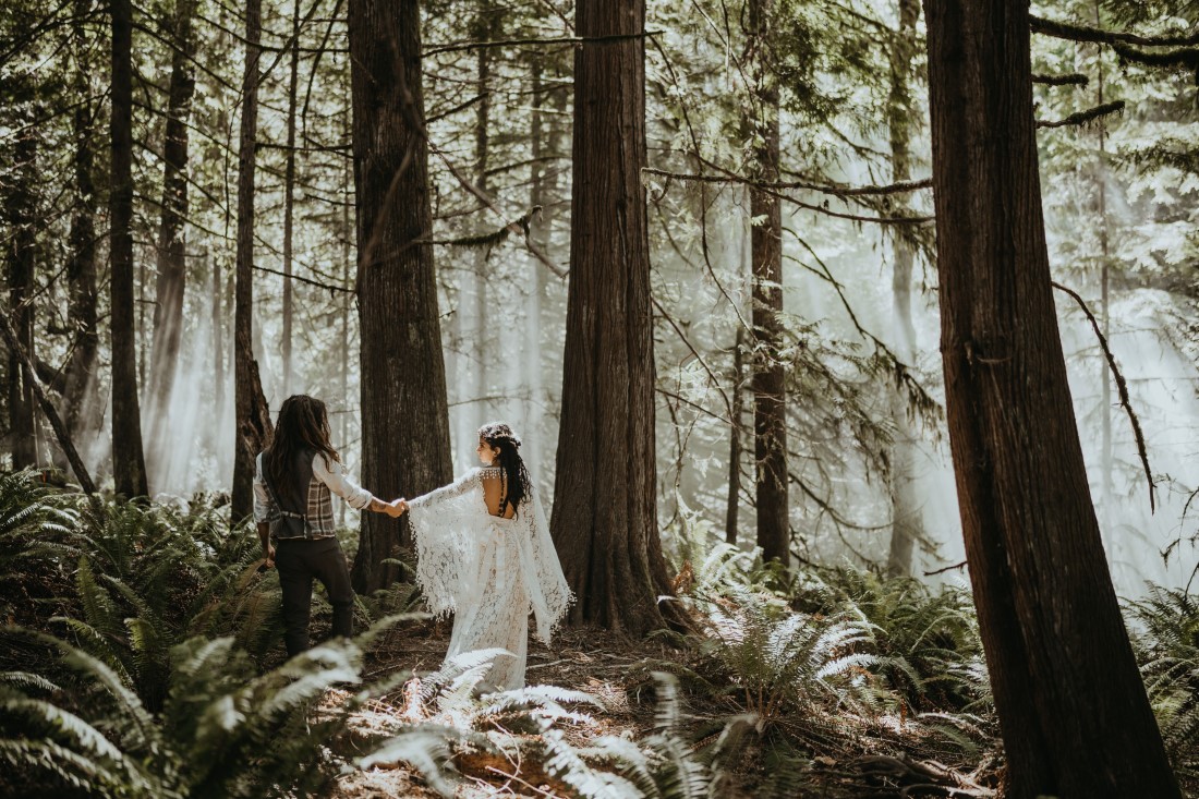Bride and groom hold hands in the Vancouver Island forest