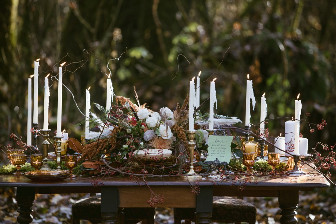 Tall white taper candles on fall outdoor wedding reception table