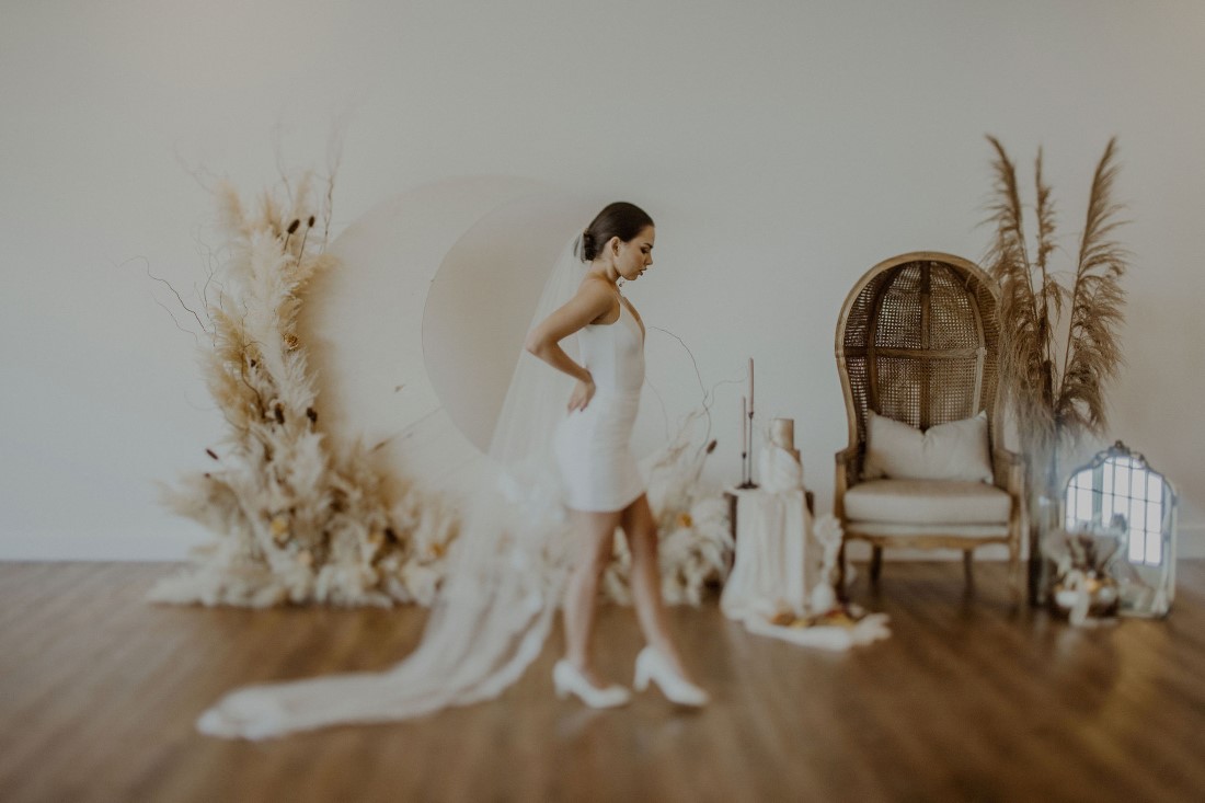 Bride in mini skirt and long polka dot veil with pampas grass