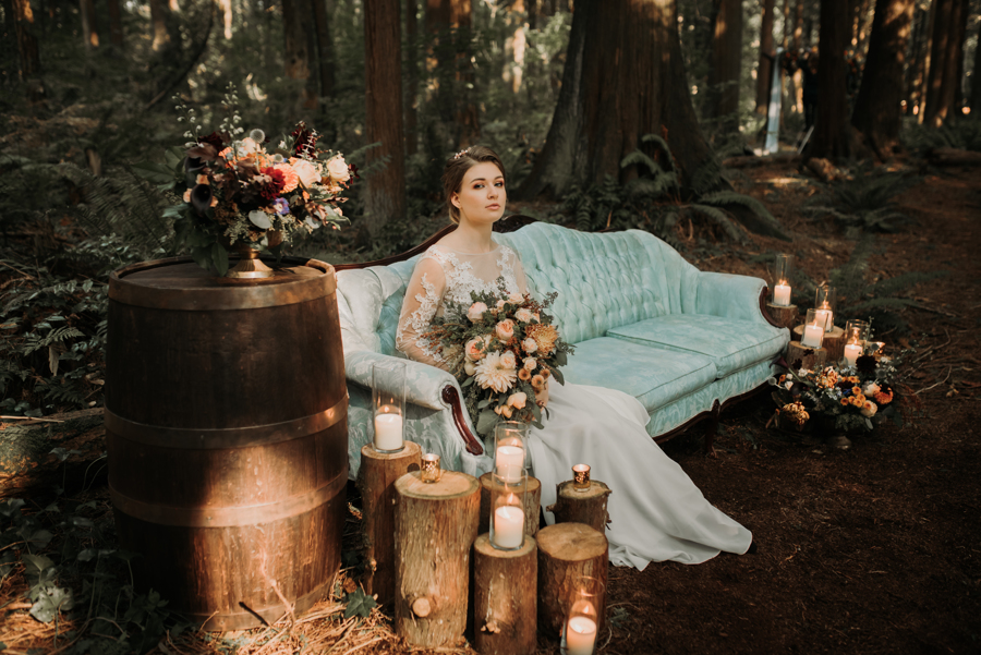 Forest Glam Inspiration bride sits on blue vintage couch in the West Coast rainforest