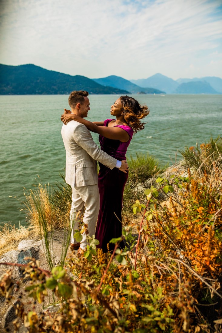 Newlyweds along Vancouver water edge with bride wearing purple velvet gown