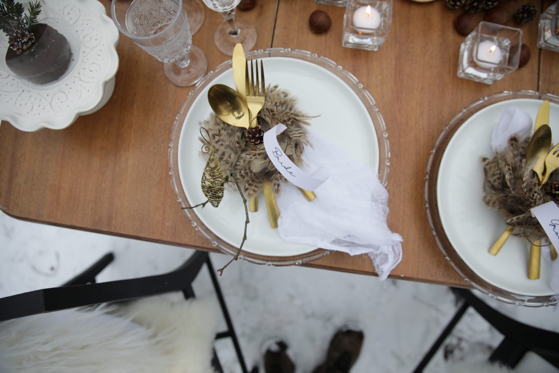 Winter Wedding reception table with pine cones and feathers