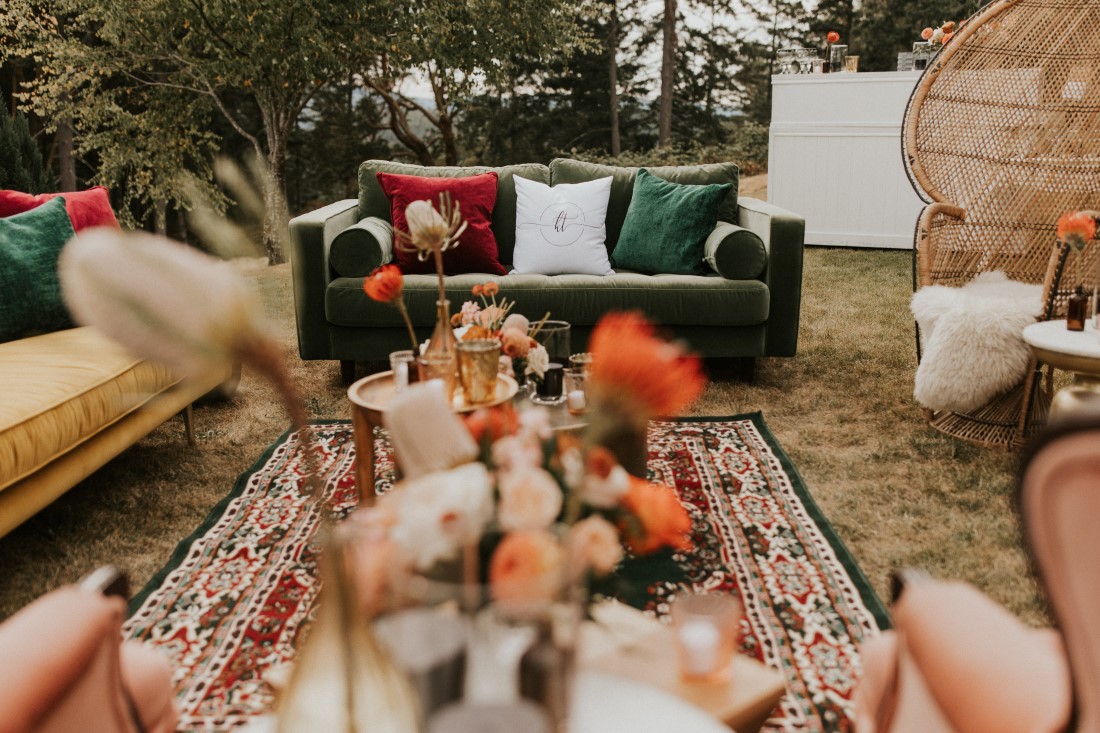 Green couch sits outdoors beside wedding reception table at Villa Eyrie