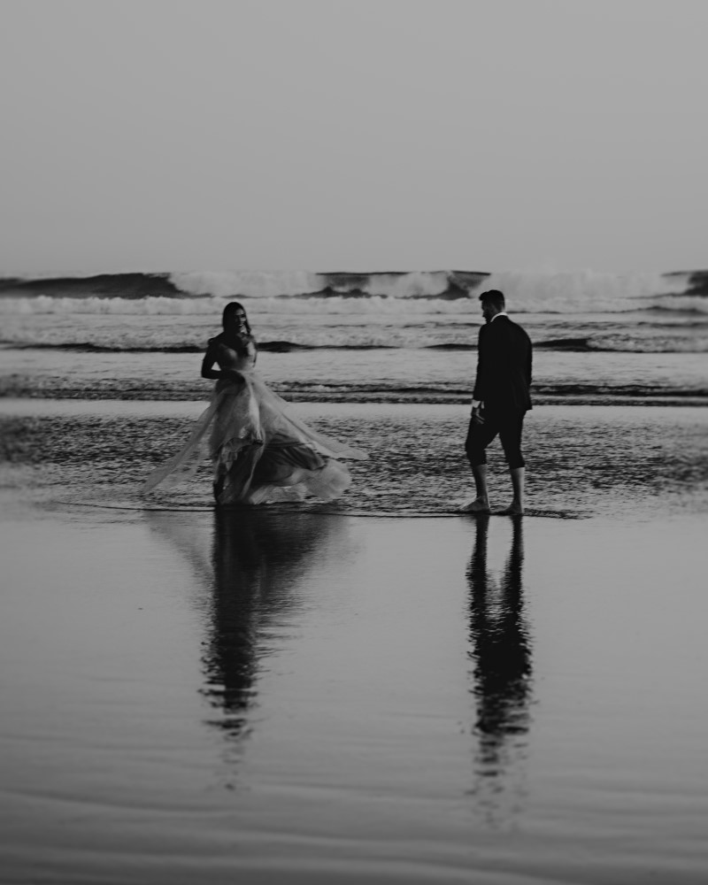 Couple walk through the Vancouver Island beach tide