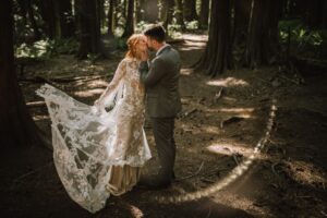 Bride and groom in sundappled forest on Vancouver Island