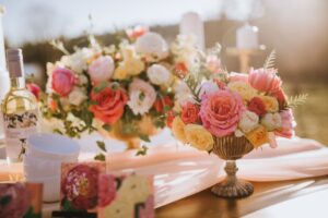 Pink yellow and peach rose bouquets on garden wedding table
