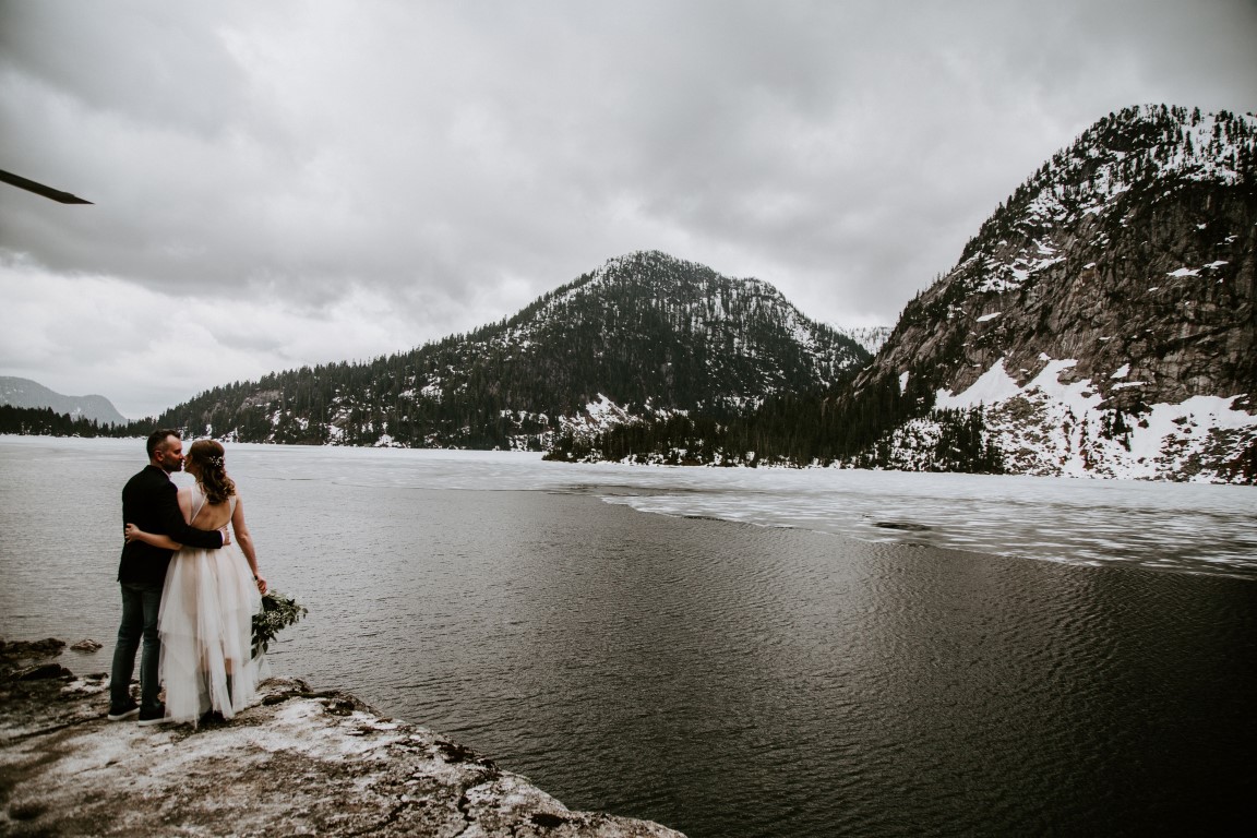 Newlyweds walk along mountain top lake after Vancouver elopement