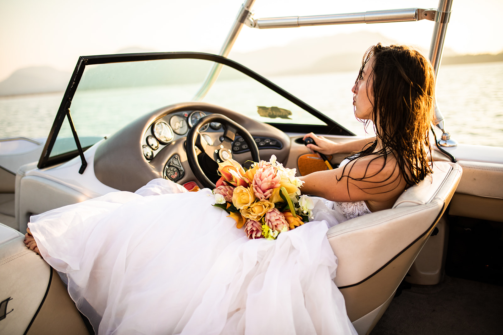 Bride sits in Captains chair of boat 