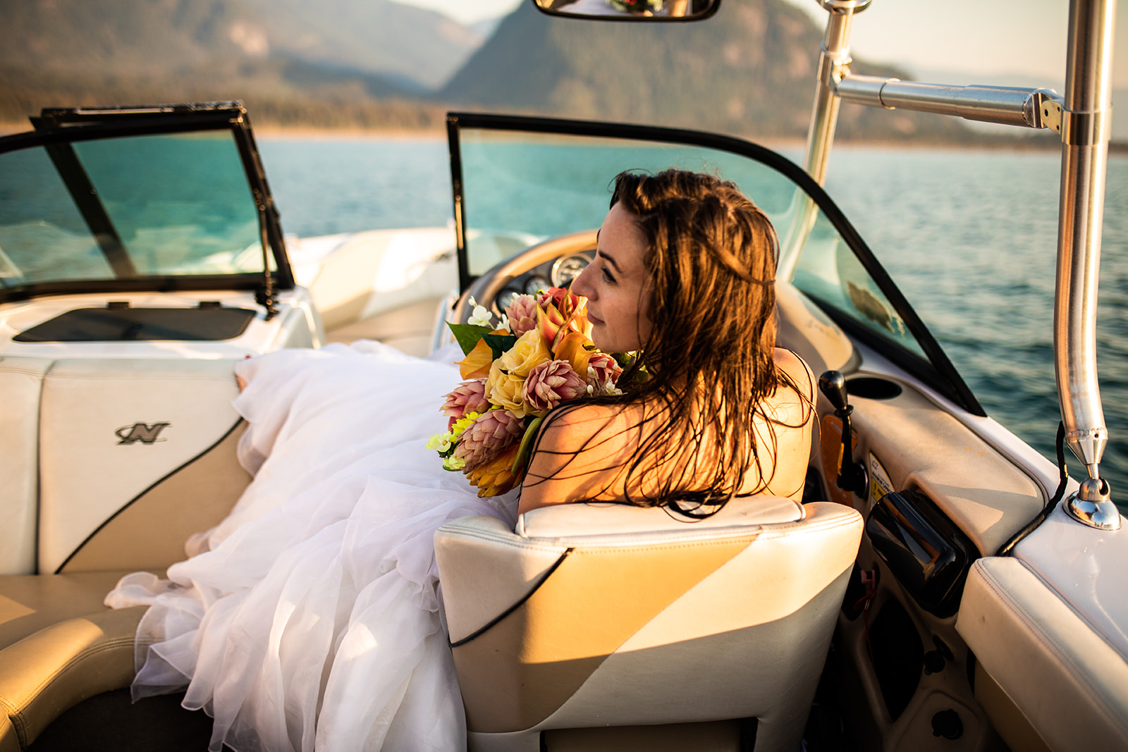 Surfer Bride holds bouquet in speed boat 