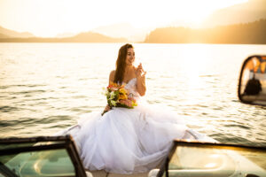 Bride sits on front of boat on Vancouver Lake