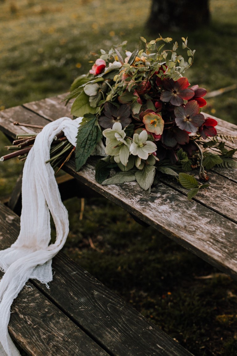 bridal bouquet of ivy, hellebores, ferns with flowing white ribbons