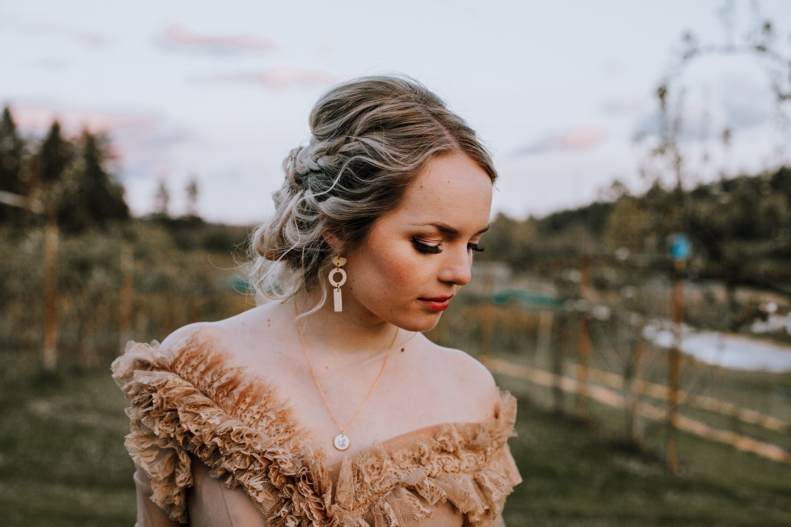 bride in peach gown with updo and earrings by Elyse Anna Photography