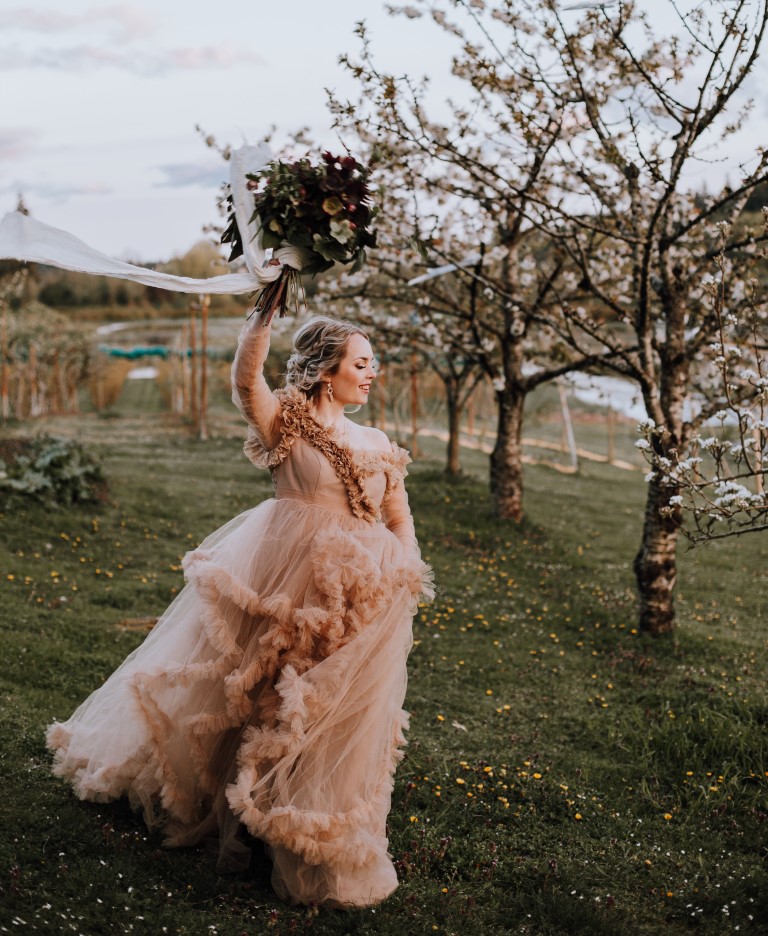 bride holds bouquet in the air 