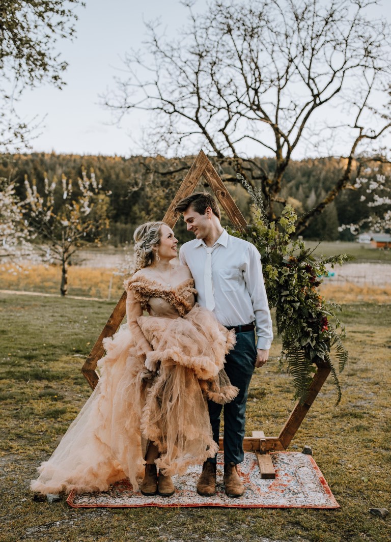 newlyweds in front of ceremony backdrop on Yellow Point Farm Nanaimo