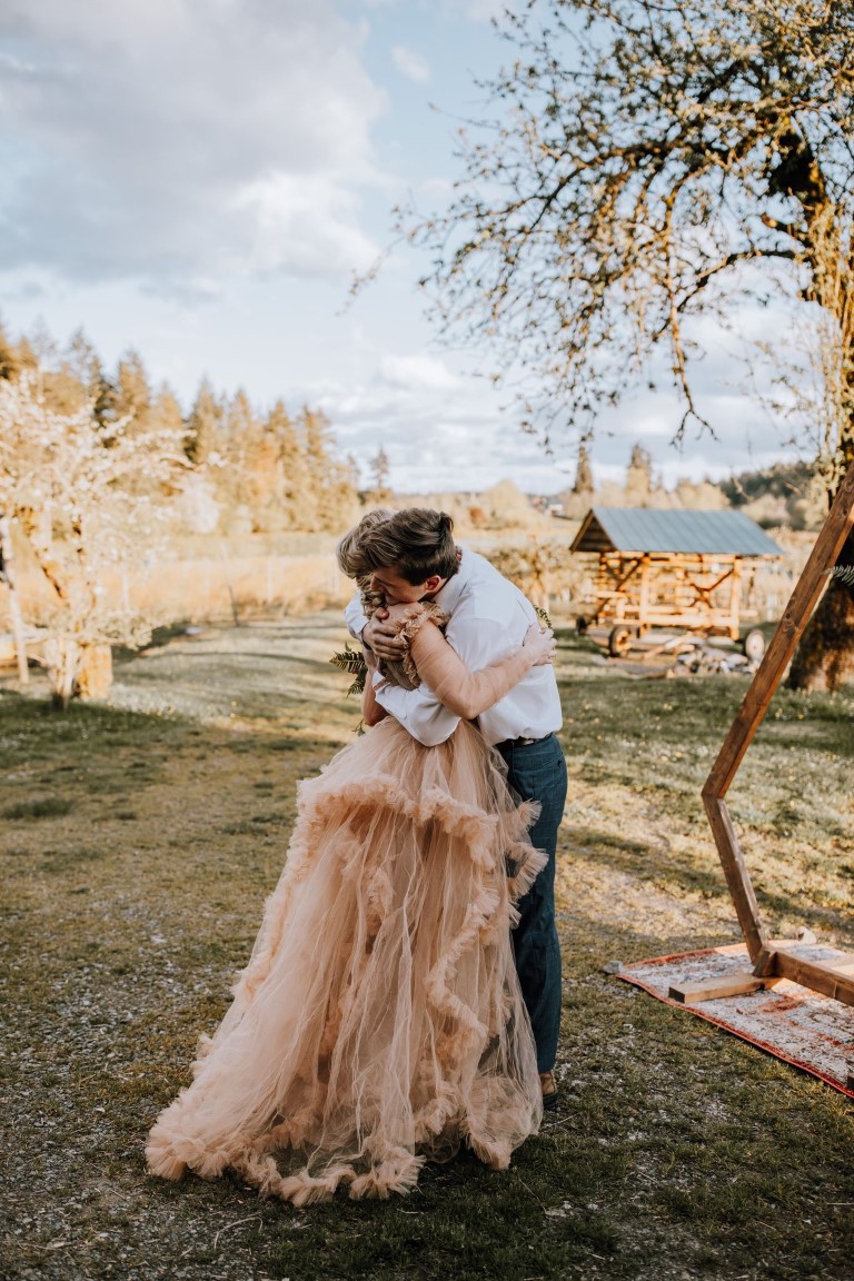 newlyweds embrace after farm ceremony