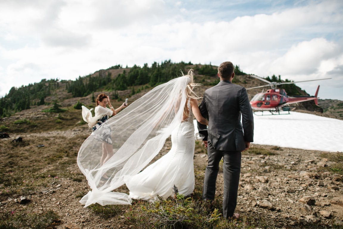 Groom and Bride with veil in front of helicopter