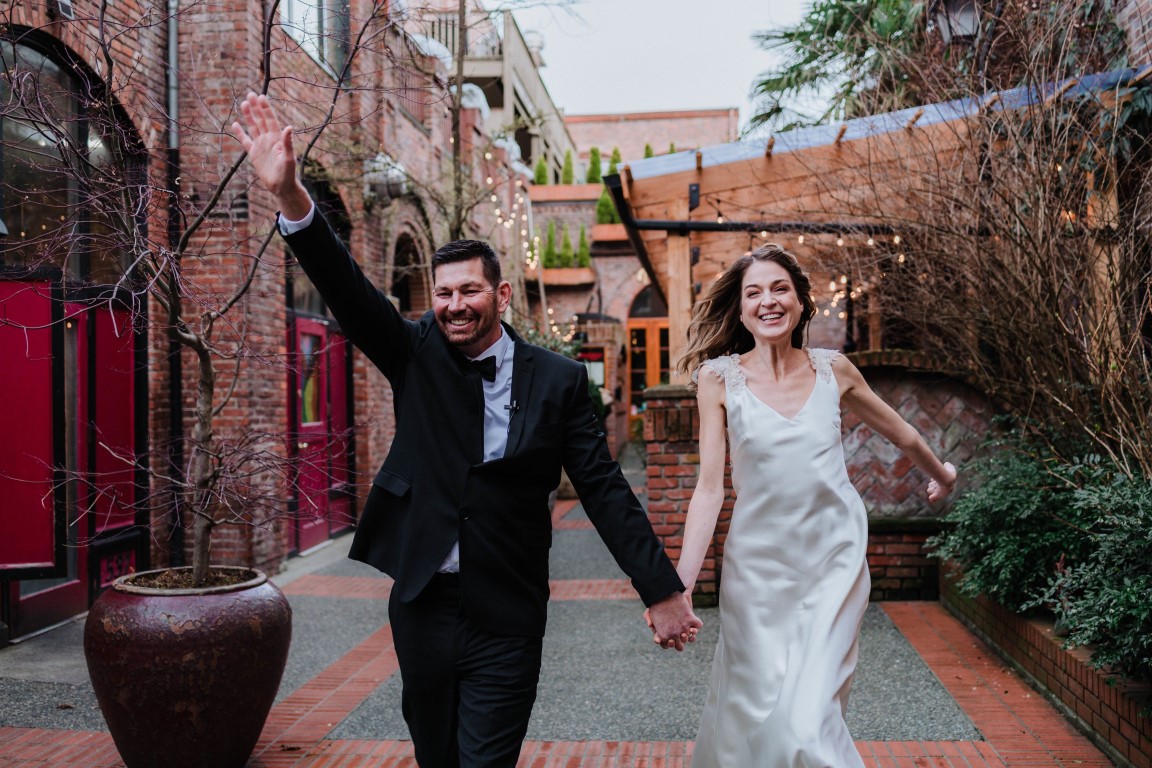 Newlyweds holding hands in the downtown district of Vancouver Island